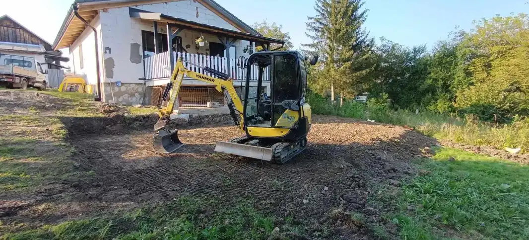 Mini bager Yanmar pri výkopových prácach v záhrade